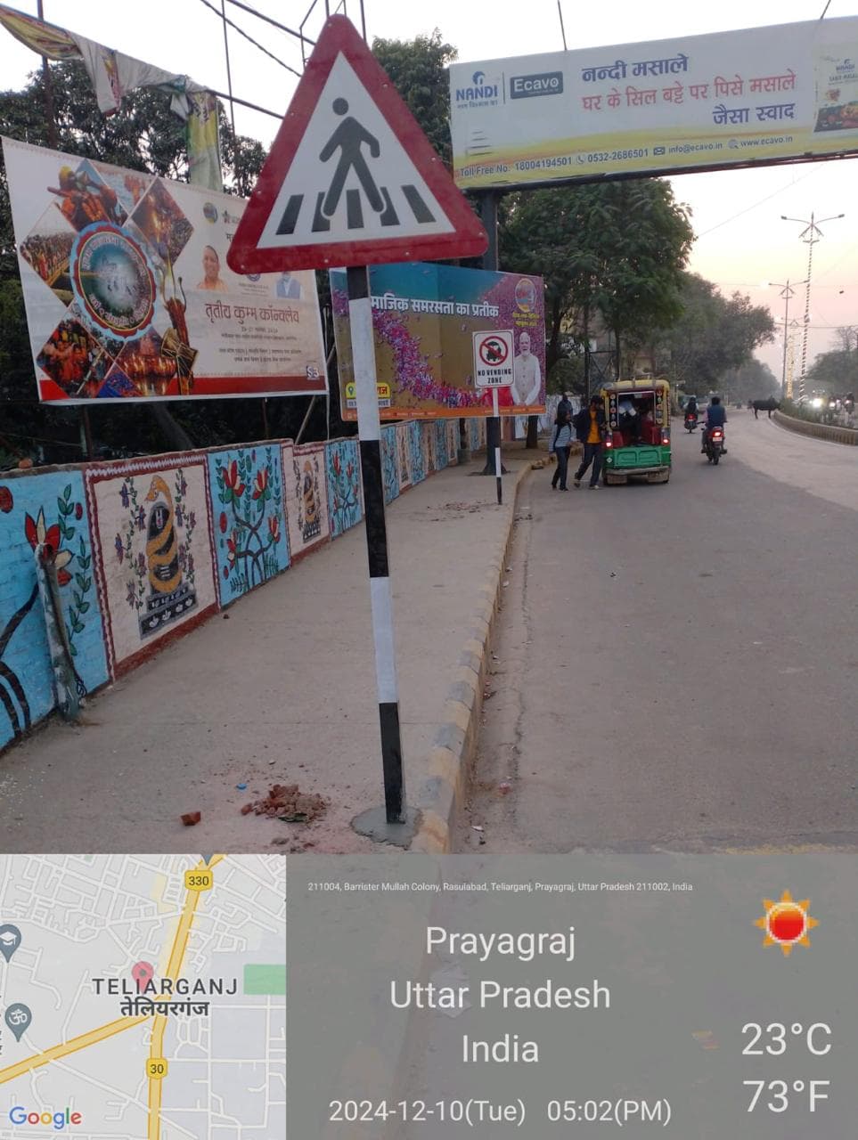 Colorful folk art murals along roadside with signage